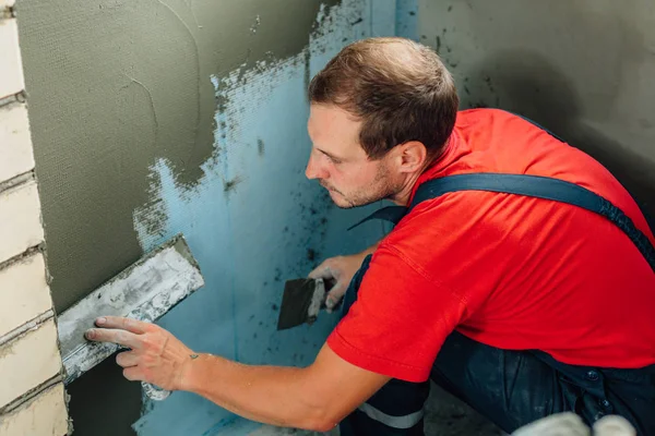 close up plasterer concrete worker at wall