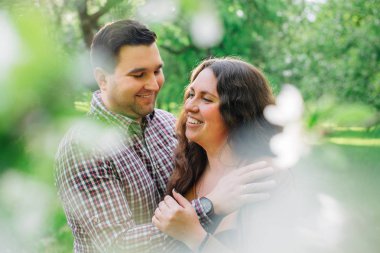 Çiçek bahçesinde sarılma aşık genç şık mutlu çift. Romantik Tarih açık havada olan kadın ve erkek.