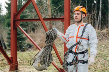 Üniforma ve kask endüstriyel dağcı ipi el ile çalışmaya hazır. Profesyonel çalışan.