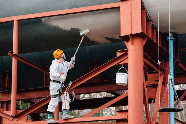 ヘルメットと制服絵水タワーで工業用の昇降機 高さに取り組んでプロ画家 危険な仕事 極端な職業 — ストック写真