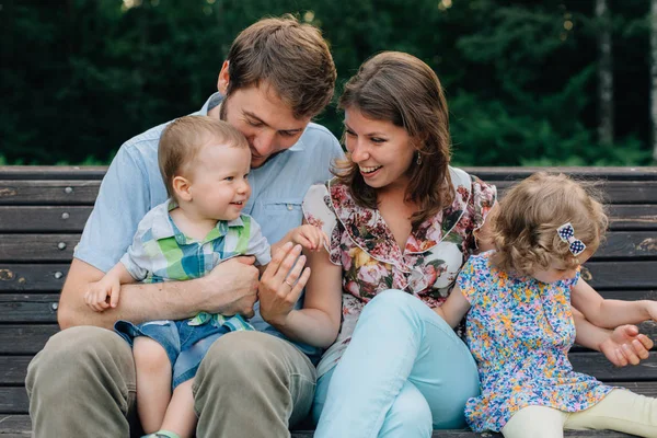 Familia Risa Joven Cuatro Sentados Banco Madera Padres Con Niños — Foto de Stock