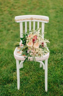 güzel düğün buket eski beyaz sandalye ayakta çim üzerinde yalan. 