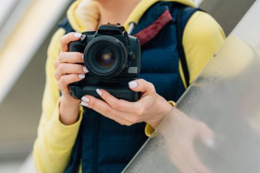 Kız ellerinde profesyonel kamera ile. Kadın fotoğrafçı yakın çekim.