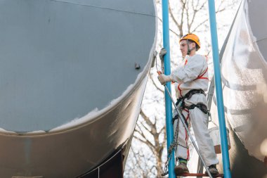 Endüstriyel dağcı kask ve Tekdüzen resim su kulesi. Profesyonel ressam yükseklik üzerinde çalışıyor. Riskli iş. Aşırı işgal.