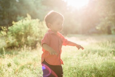Küçük şirin çocuk yaz parkında eğleniyor. Mutlu çocuk dışarıda