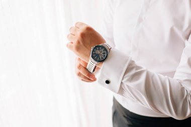 Damat saat takıyor. Adam hazırlanıyor. Düğün günü.