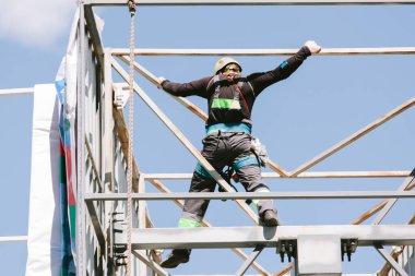 Miğferli ve boyuyla çalışan endüstriyel tırmanışçı. Riskli bir iş. Profesyonel işçi.