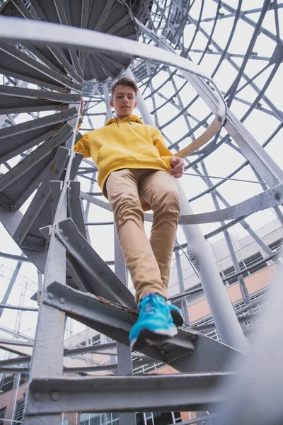 Een Jongeman Met Een Gele Capuchon Turquoise Sneakers Staat Een — Stockfoto