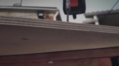 Elektrikli vida sürücüsü yavaş çekimde kontrplak bir levha vida vidalar ve elektrikli aletler ile ahşap yapı bağlama ve monte