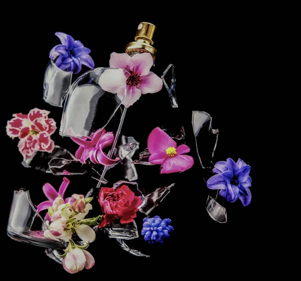 Glass Perfume Bottle Shatters Bright Spring Flowers Clouds Blue Purple — Stock Photo, Image