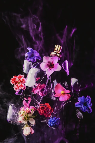 Skleněná Lahvička Parfémem Roztříští Tmavém Pozadí Vytrysknou Jasné Jarní Květiny — Stock fotografie
