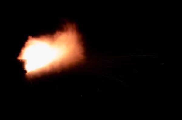 黒い背景の銃火からのショット 飛んで火花と燃える排気 炎がパイプから破裂します ジェットエンジンのノズルから火が出てくる — ストック写真