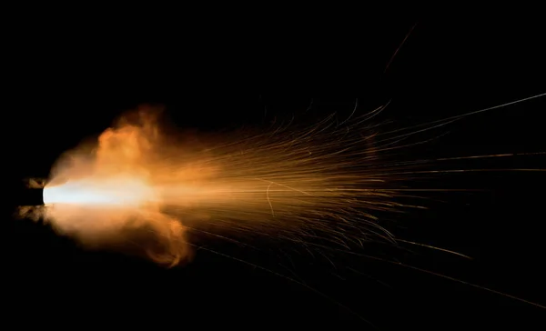 黒い背景の上の銃器からのショット 飛んで火花と燃える排気 パイプから破裂する炎 — ストック写真