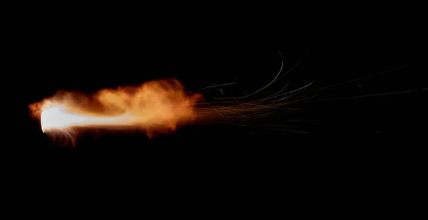 A shot from a firearm on a black background, a fiery exhaust with flying sparks, flames bursting out of the pipe. Fire comes out of the nozzle of a jet engine