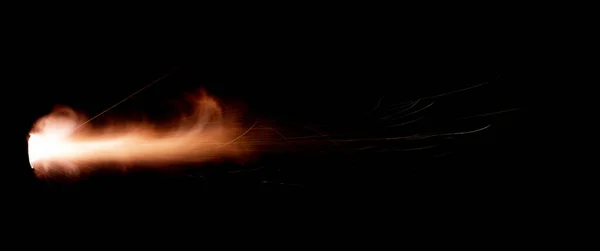 A shot from a firearm on a black background, a fiery exhaust with flying sparks, flames bursting out of the pipe. Fire comes out of the nozzle of a jet engine