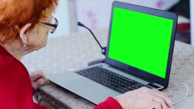 Yaşlı bir kadın telefonla konuşur ve dizüstü bilgisayarda çalışır, bir büyükanne sosyal ağları ve akıllı telefonu kendi başına iletişim kurmak için kullanır, bir emekli bilgi teknolojisinde uzmanlaşır