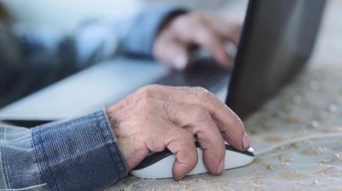 Dizüstü bilgisayarda yaşlı bir adam. Büyükbaba evde kalıyor ve sosyal ağlar aracılığıyla ailesi ve arkadaşlarıyla iletişim kuruyor. Salgın sırasında emeklilerin evlerinin geri çekilmesi.