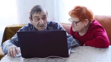 Yaşlı bir çift sosyal ağlarda uzmanlaşıyor. Emekliler, akrabaları ve arkadaşlarıyla kendi kendilerini izole etme koşullarında dizüstü bilgisayarla iletişim kurarlar. Mutlu yaşlı insanlar selfie çeker. 