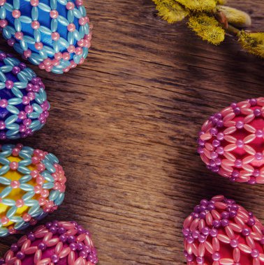 Yeşil ve ahşap arka planda boncuklu Paskalya yumurtaları. Paskalya bayramının sembolü boncuklarla kaplıdır. Sepetteki parlak Paskalya yumurtaları