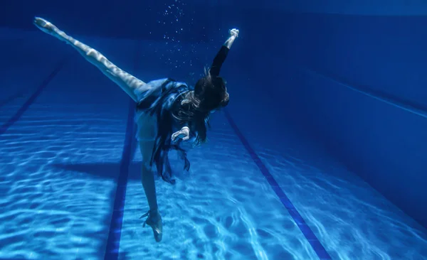 バレリーナはプールに飛び込み水の下と水面の上でスレンダーなプロのダンサーポイントの靴の水の下で凍った動き踊り — ストック写真