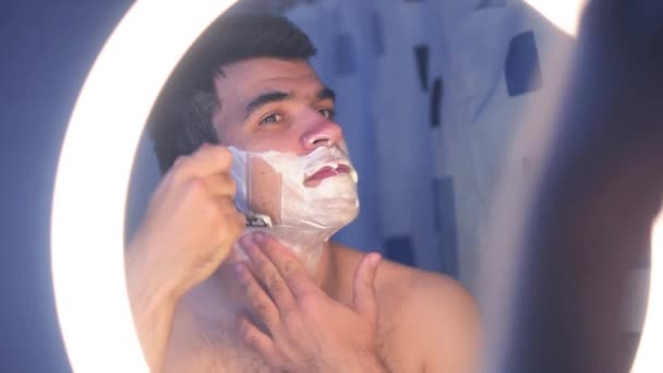 Ένας Νεαρός Άνδρας Ξυρίζεται Στο Μπάνιο Αφρό Ξυρίσματος Στο Πρόσωπο — Αρχείο Βίντεο