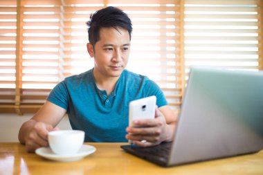 Genç adam evde çalışıyor..