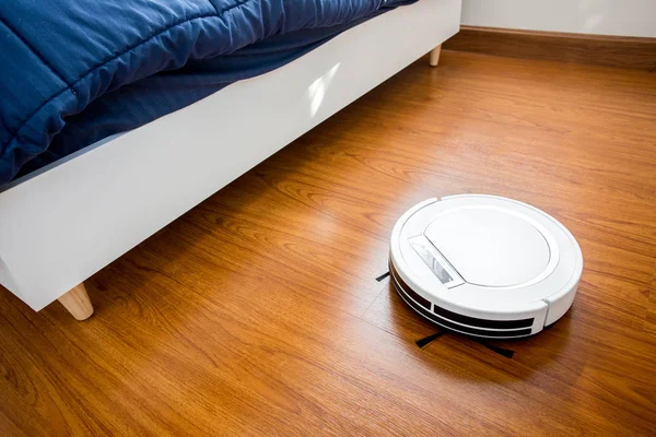 在卧室里的机器人真空吸尘器。. — 图库照片