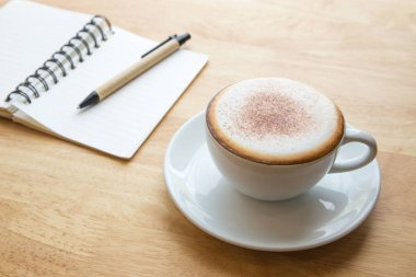 Açık defter ile kahve fincanı.