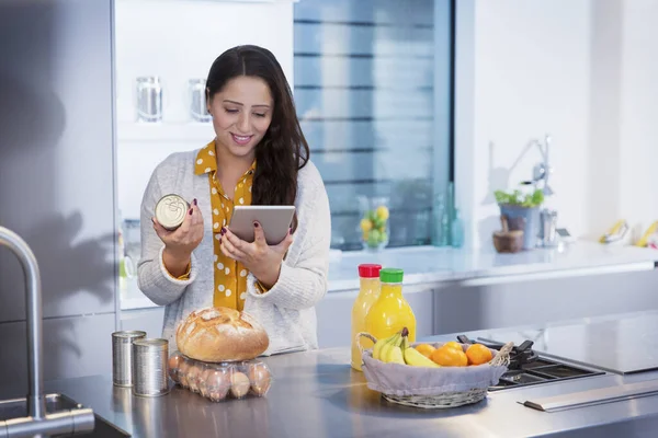 Mulher Com Tablet Digital Verificando Rótulos Alimentos Cozinha — Fotografia de Stock