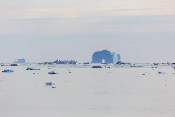 穏やかな大西洋上で遠くに雄大な氷山のアーチ グリーンランド — ストック写真
