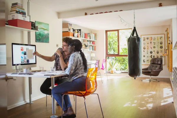 Young creative entrepreneurs working at computer in home office — Stock Photo