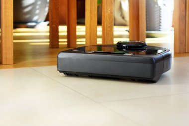 Robot elektrikli süpürge parlak döşenmiş ve ahşap zemin üzerinde