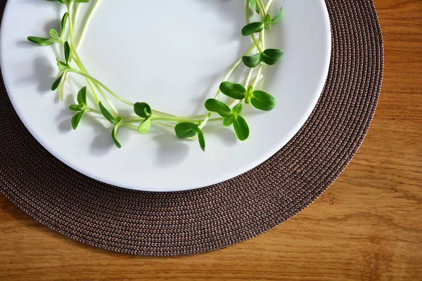 緑色のひまわりの芽の束は 白い皿の上提供しています イースター テーブル料理装飾 — ストック写真