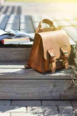 Vintage Doğal deri sırt çantası ve gri rustik Ahşap merdiven kitapları