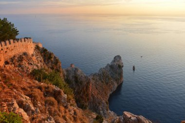 Gün batımında Alanya Şatosu 'ndan güzel deniz ve kayalar görünüyor.