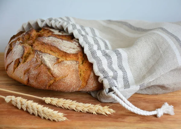 Rolo de pão saboroso no saco de pão de linho reutilizável zero no woode — Fotografia de Stock