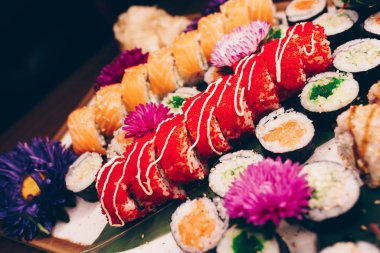 Flat Lay 'den büyük bir lezzetli suşi seti. Geleneksel restoranda bir tabakta Japon çiğ balığından bir sürü Philadelphia dürümü var. Japon yemek menüsü servisi