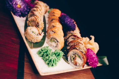 Flat Lay 'den büyük bir lezzetli suşi seti. Geleneksel restoranda bir tabakta Japon çiğ balığından bir sürü Philadelphia dürümü var. Japon yemek menüsü servisi