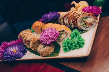 Flat Lay 'den büyük bir lezzetli suşi seti. Geleneksel restoranda bir tabakta Japon çiğ balığından bir sürü Philadelphia dürümü var. Japon yemek menüsü servisi
