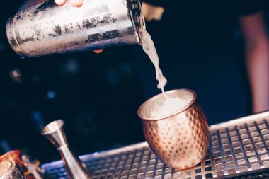 Barmen, barın tezgahına süzgeç gibi beyaz kokteyl döker. Profesyonel bakış açısı. Moda tarzı alkollü içecek. Gece kulübünde tasarımcılar ve konsept servisi barmeni.
