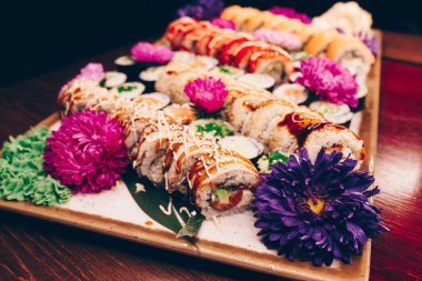 Flat Lay 'den büyük bir lezzetli suşi seti. Geleneksel restoranda bir tabakta Japon çiğ balığından bir sürü Philadelphia dürümü var. Japon yemek menüsü servisi