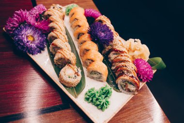 Flat Lay 'den büyük bir lezzetli suşi seti. Geleneksel restoranda bir tabakta Japon çiğ balığından bir sürü Philadelphia dürümü var. Japon yemek menüsü servisi