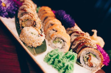 Flat Lay 'den büyük bir lezzetli suşi seti. Geleneksel restoranda bir tabakta Japon çiğ balığından bir sürü Philadelphia dürümü var. Japon yemek menüsü servisi