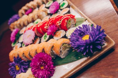 Flat Lay 'den büyük bir lezzetli suşi seti. Geleneksel restoranda bir tabakta Japon çiğ balığından bir sürü Philadelphia dürümü var. Japon yemek menüsü servisi