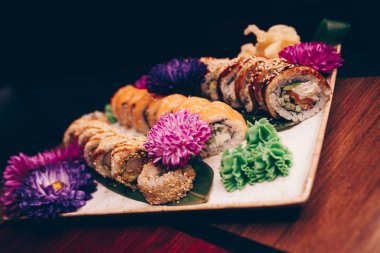 Flat Lay 'den büyük bir lezzetli suşi seti. Geleneksel restoranda bir tabakta Japon çiğ balığından bir sürü Philadelphia dürümü var. Japon yemek menüsü servisi