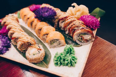 Flat Lay 'den büyük bir lezzetli suşi seti. Geleneksel restoranda bir tabakta Japon çiğ balığından bir sürü Philadelphia dürümü var. Japon yemek menüsü servisi