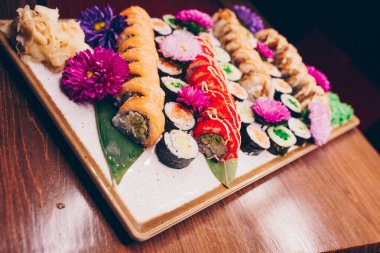 Flat Lay 'den büyük bir lezzetli suşi seti. Geleneksel restoranda bir tabakta Japon çiğ balığından bir sürü Philadelphia dürümü var. Japon yemek menüsü servisi
