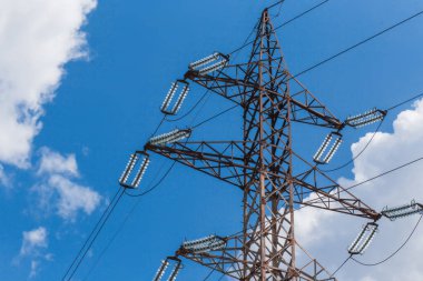 Elektrik iletim hatları (yüksek voltaj kulesi) yüksek voltaj hatları. Elektrik transferi, tarımsal bölgelerden geçerek destekleniyor. Güneşli bir gün ve mavi gökyüzünde sirus bulutları var.