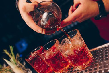 Barmen, barın tezgahına süzgeç gibi beyaz kokteyl döker. Profesyonel bakış açısı. Moda tarzı alkollü içecek. Gece kulübünde tasarımcılar ve konsept servisi barmeni.