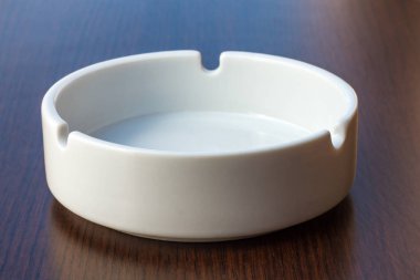 Masanın üzerinde yuvarlak beyaz kül tablası